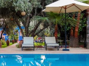 two chairs and an umbrella next to a pool at Le Bleu House in Marrakech