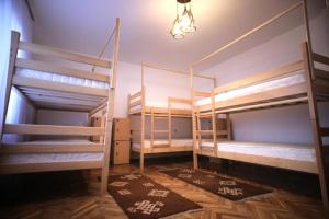 a room with three bunk beds and a lamp at Hostel Bushati in Prizren