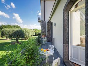 a balcony with a table and chairs and a window at Donna Carmela Resort & Lodges in Riposto