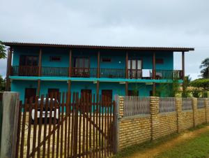 niebieski dom za płotem w obiekcie Vila Samin Moitas w mieście Praia de Moitas