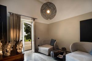 a living room with a couch and a chair at Donna Carmela Resort & Lodges in Riposto