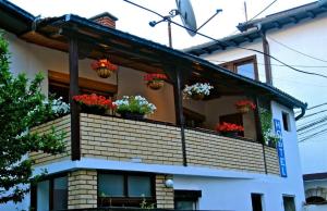 a house with potted plants on a balcony at Hostel Bushati in Prizren