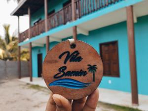 une personne tenant un morceau de bois avec les mots mic été sur lui dans l'établissement Vila Samin Moitas, à Praia de Moitas