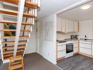 a kitchen with white cabinets and a spiral staircase at 6 person holiday home in Hemmet in Hemmet