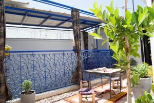 un patio con una valla azul, una mesa y sillas en Riad Yenna en Marrakech
