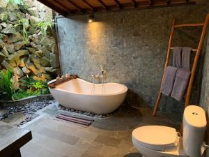 uma casa de banho com banheira e WC em Aix Cottage Ubud em Ubud