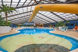 a large swimming pool with a slide in a building at Bewles Caravan in Rhyl