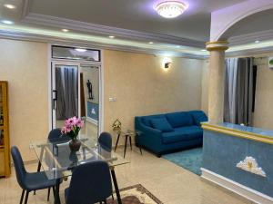 a living room with a blue couch and a table at RÉSIDENCE MARTHA in Yaoundé