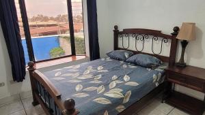 1 dormitorio con 1 cama y vistas a la piscina en Pool Party House, en Guatemala