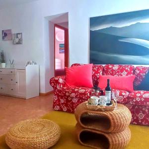 sala de estar con sofá rojo y mesa en Casa Nela. Rural y acogedora en Las Puntas El Hierro en Frontera
