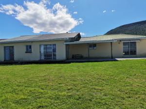 a house with a grass field in front of it at Village Stay Ngcamngeni in Debe Nek