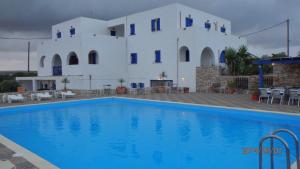 a villa with a swimming pool in front of a building at Mylos in Livadi
