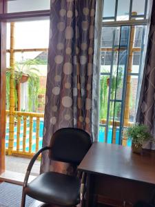 a chair sitting next to a table and a window at Casa Amarello in Lima