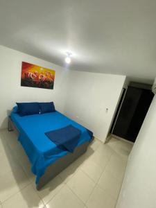 a bedroom with a blue bed and a flat screen tv at Hogar dulce hogar in Cartagena de Indias