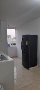 a black refrigerator in a room with a window at Hogar dulce hogar in Cartagena de Indias