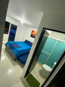 a bedroom with a blue bed and a toilet at Hogar dulce hogar in Cartagena de Indias