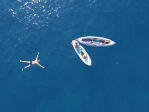 a person swimming in the water next to a boat at Villa sunbeach in Roquebrune-sur-Argens