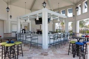 a patio with tables and chairs and a bar at Storey Lake Home W Pool Mins To Disney 4br Waterpark in Kissimmee