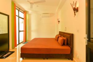 - une chambre avec un lit doté de draps orange et une fenêtre dans l'établissement 2B1 weligama, à Weligama