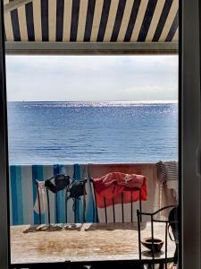 a view of the ocean through a window at Villa sunbeach in Roquebrune-sur-Argens