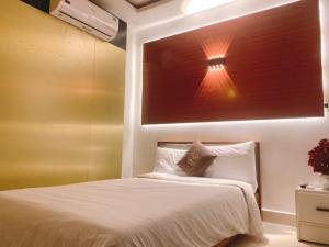 a bedroom with a bed with a light above it at Poetic Hue Hotel & Spa in Hue