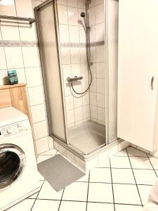 a shower with a glass door in a bathroom at Ferienwohnung Diana in Sexau +13 photos