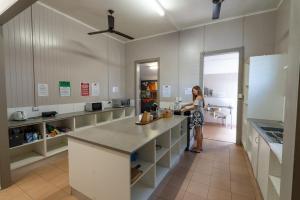 a woman standing in a kitchen with a counter at The Jack Backpackers in Cairns