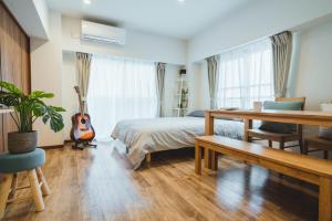 a bedroom with a bed and a guitar in it at City Hideout in Tokyo