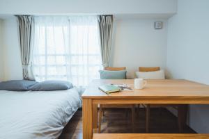 a bedroom with a table and a bed and a window at City Hideout in Tokyo