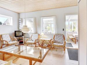 ein Wohnzimmer mit einem Couchtisch aus Glas und Stühlen in der Unterkunft Holiday home Sjølund XXI in Sjølund