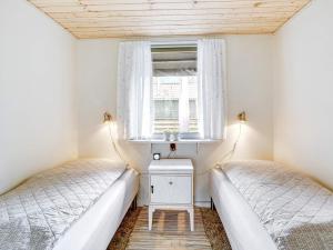 2 Betten in einem kleinen Zimmer mit Fenster in der Unterkunft Holiday home Sjølund XXI in Sjølund