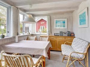 ein Esszimmer mit einem Tisch, Stühlen und einem Fenster in der Unterkunft Holiday home Sjølund XXI in Sjølund