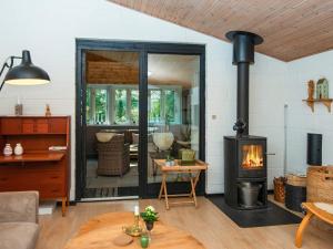 - un salon avec un poêle à bois dans l'établissement 4 person holiday home in Ebeltoft-By Traum, à Ebeltoft 33 autres photos