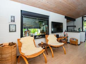 un salon avec deux chaises et une télévision dans l'établissement 4 person holiday home in Ebeltoft-By Traum, à Ebeltoft