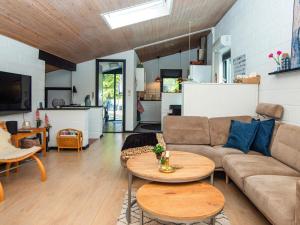 a living room with a couch and tables and a kitchen at Holiday home Ebeltoft CLXXXI in Ebeltoft