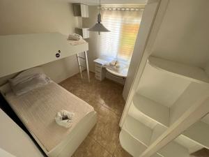 ein kleines Schlafzimmer mit einem Bett und einem Waschbecken in der Unterkunft Jardim Botânico Curitiba in Curitiba