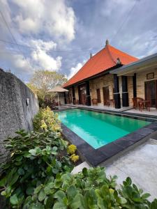 a swimming pool in front of a house at Nari Homestay in Canggu