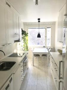 uma cozinha branca com uma mesa branca e uma janela em Avara keskusta asunto + oma ilmainen parkkipaikka em Tampere