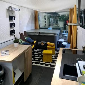 a living room with a bed and yellow chairs at loft SPA nature et détente in Messy