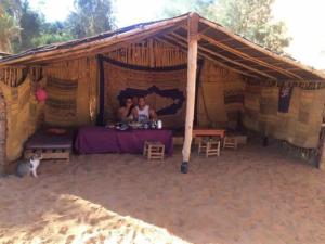 Dos personas en una tienda de campaña con una mesa en Obira Oasis Merzouga Camp, en Merzouga