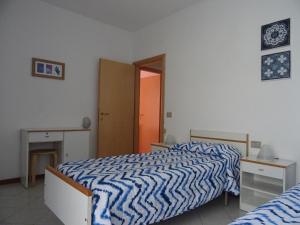 Schlafzimmer mit einem Bett mit einer blauen und weißen Bettdecke in der Unterkunft La Martlona in Riccione