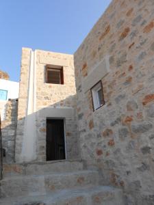 um edifício de pedra com duas janelas e uma porta em villa Elpiniki Tilos em Megálon Choríon