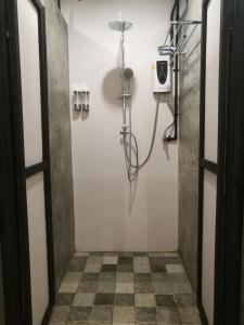 a shower in a bathroom with a tile floor at Backpack Station in Bangkok