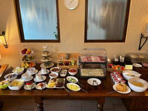 uma mesa com muitos tipos diferentes de alimentos sobre ele em Hotel garni Zum Rebstock em Naumburg