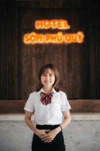 ファンランにあるKhách sạn Sớm Phú Quý - Ninh Thuậnの白いシャツと弓ネクタイの女の子