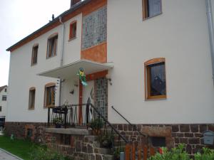 une maison blanche avec un escalier en face de celle-ci dans l'établissement Tiny-Apartment-in-Gemuenden-an-der-Wohra, à Gemünden an der Wohra