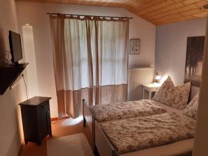 mała sypialnia z łóżkiem i oknem w obiekcie AlpenSportChalet w mieście Werfenweng