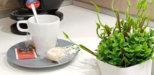 un tavolo con una tazza, un piatto e una pianta di Terra di Venere Inn a Ragusa