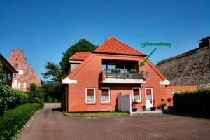 a red house with a balcony on a street at "Alte Sparkasse" Nr1 in Landkirchen