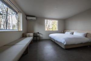 ein Schlafzimmer mit einem großen Bett und einem Fenster in der Unterkunft Auberge Hidanomori in Takayama